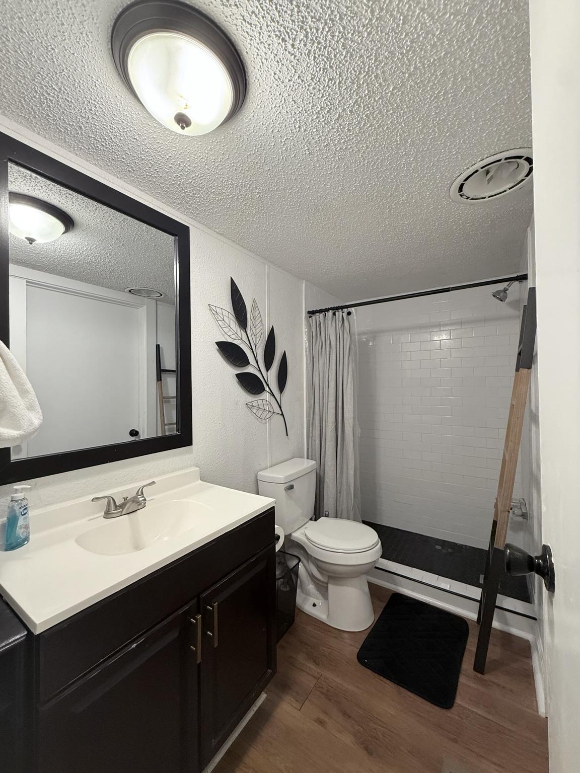 Newly renovated secondary bathroom with white subway tile shower