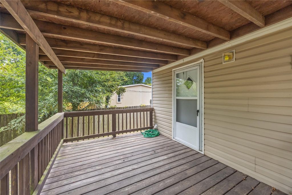 Covered rear porch overlooking the fenced backyard