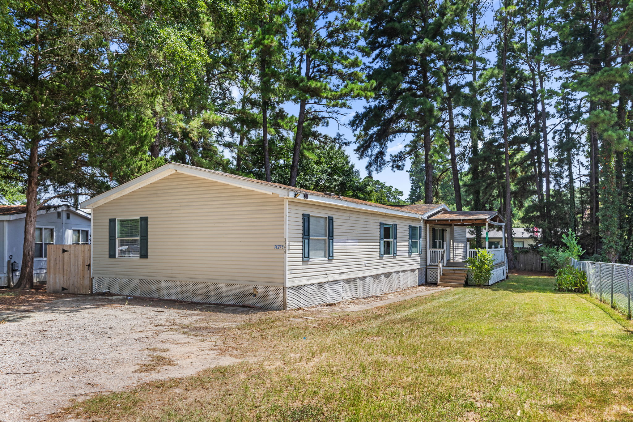 Front elevation from the gravel drive. Front door faces west. 14279 Shadow Bay Dr, Willis TX