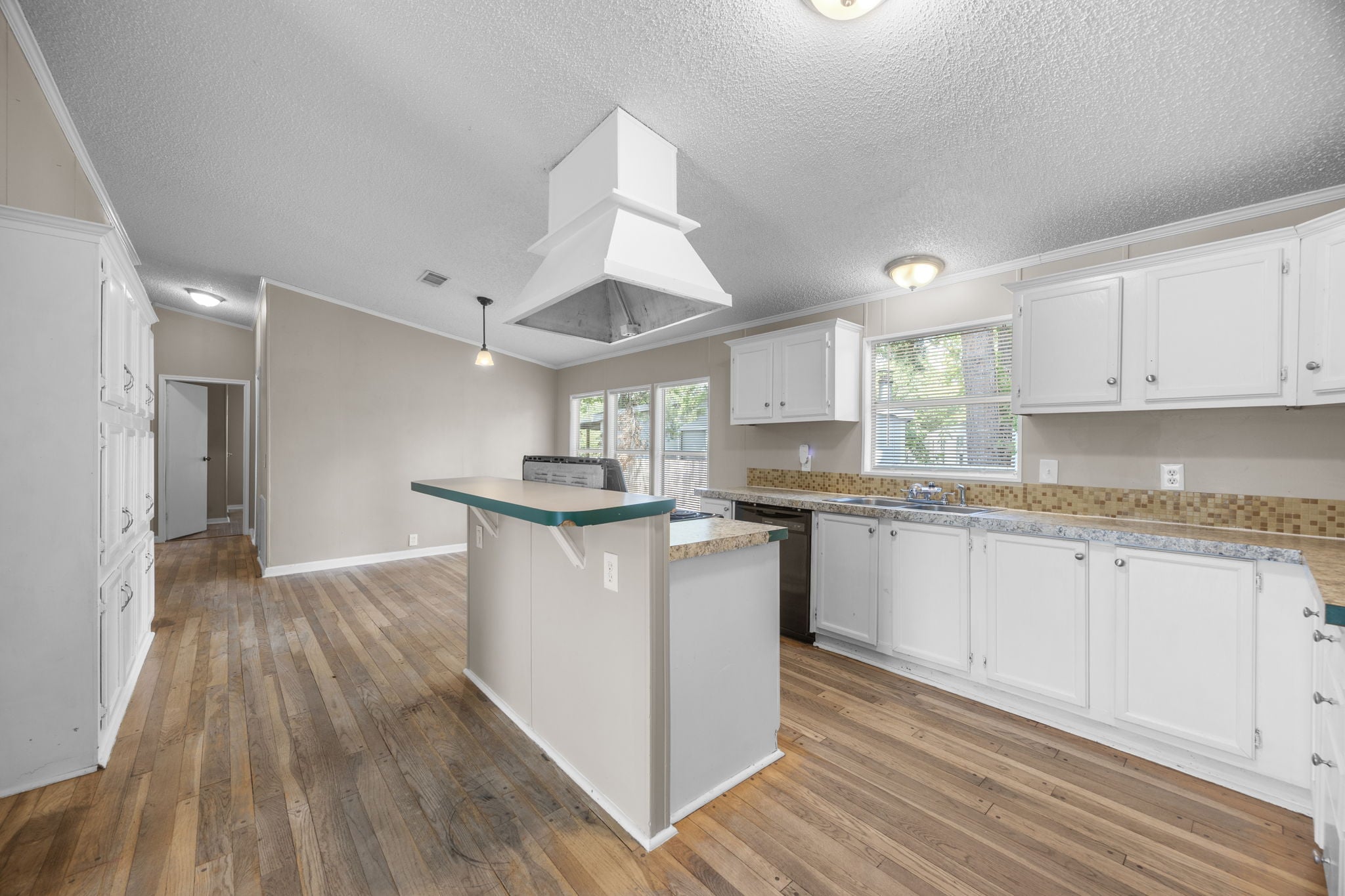 Kitchen with center island, vented range hood, and window over the sink. 14279 Shadow Bay Dr, Willis TX