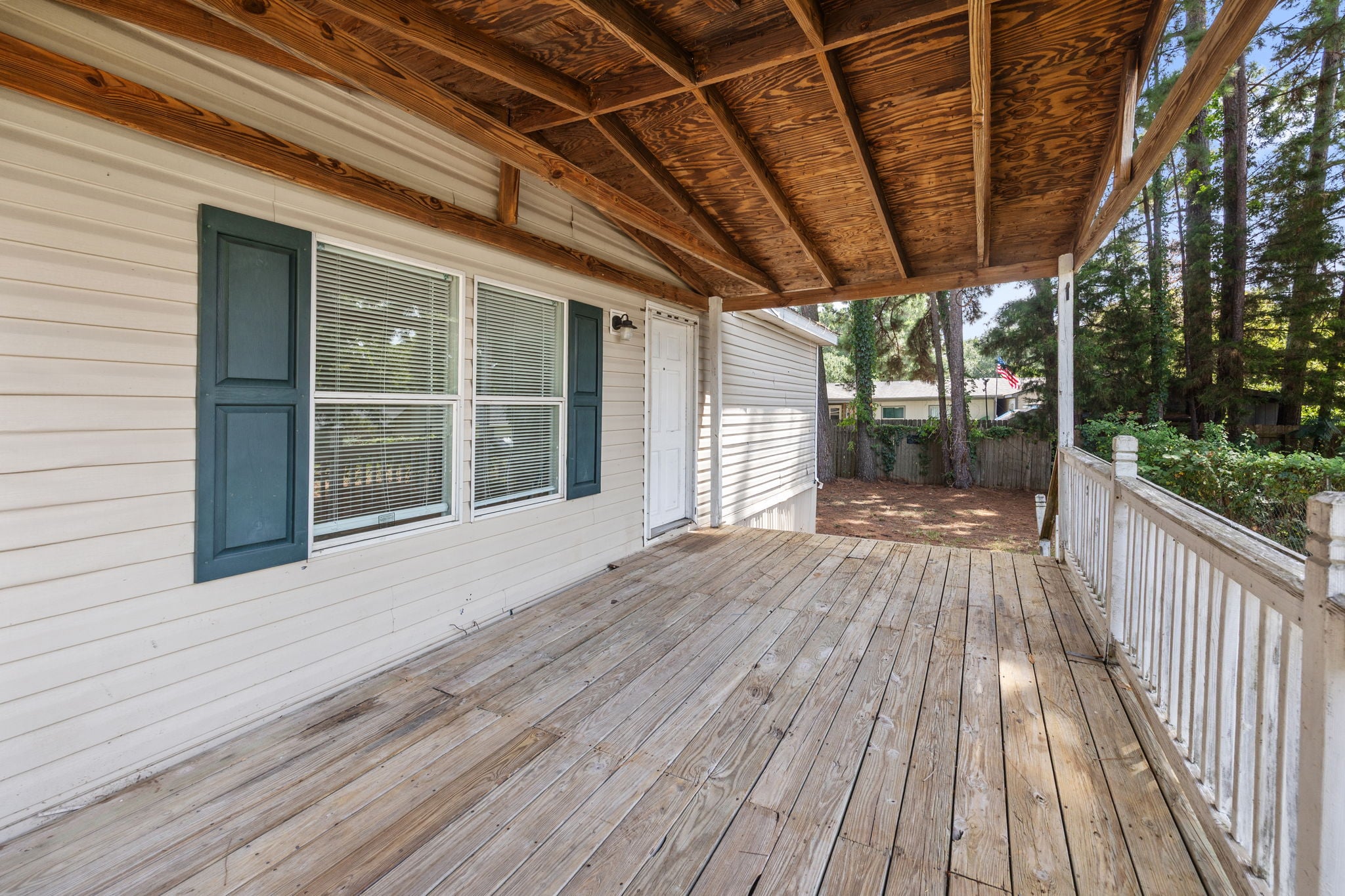 Covered front porch with wood decking and railing. 14279 Shadow Bay Dr, Willis TX